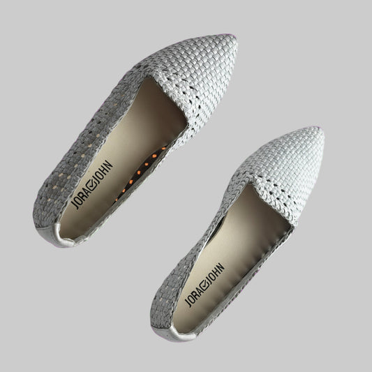 Pair of gray pointed-toe shoes on a pink background