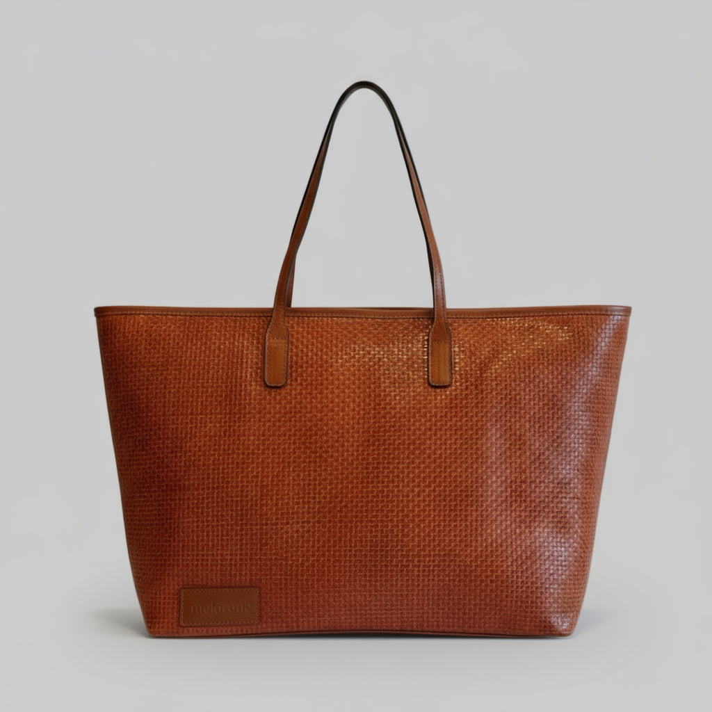 Brown woven handbag with leather handles on a white background