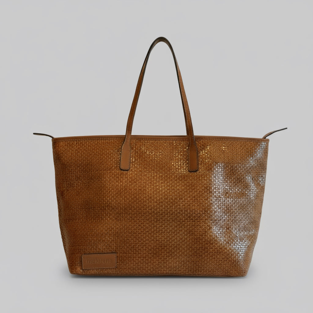 Brown woven handbag with leather handles on a beige background
