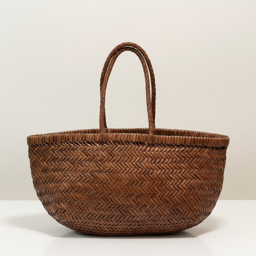 Woven basket with a decorative tag on a beige background